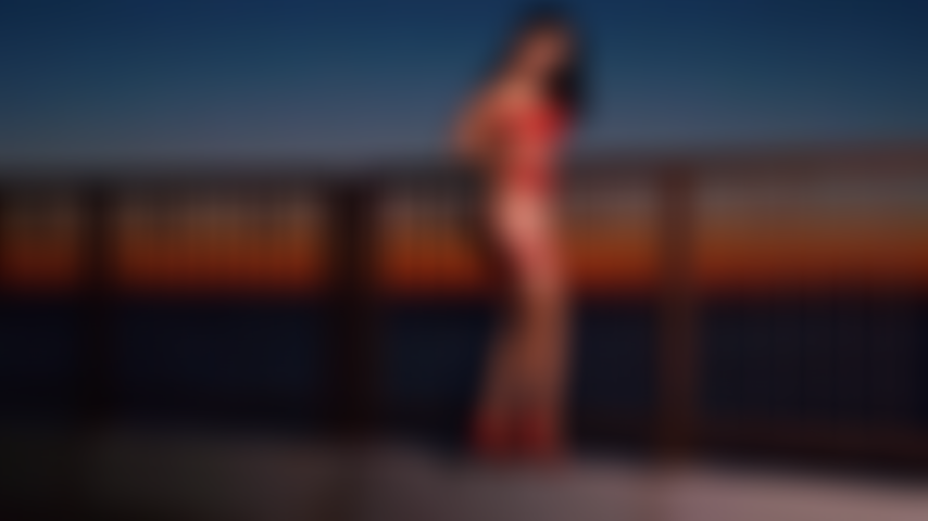Allumeuse sensuelle seins nus à la plage du lever du soleil.