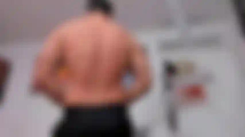 Flexing avec un pantalon d'affaires et un visage de démon pour halloween.