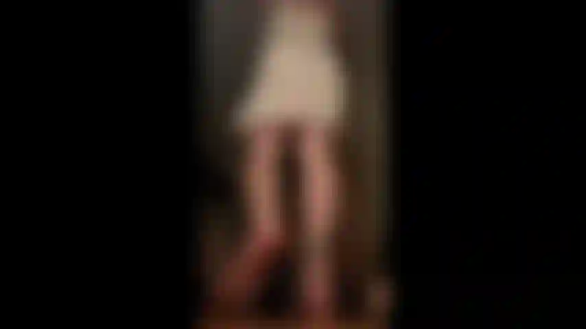 Une géante en jupe haute violette, pieds nus, un buisson poilu.