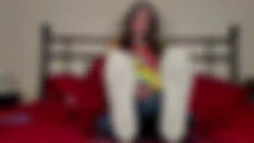 Pieds nus, entièrement habillée, enlève chaussures et chaussettes.