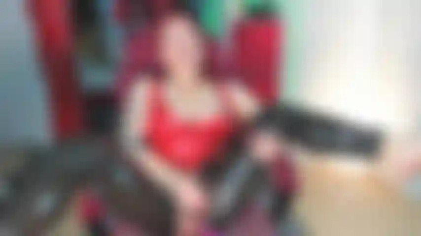 Une énorme giclée en leggings en latex noir et un haut en latex rouge.