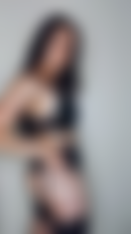 Un strip-tease sexy aux seins nus en lingerie noire.