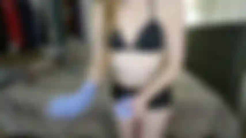 Short noir brillant, gants d'examen violets et aisselles poilues (non nues).