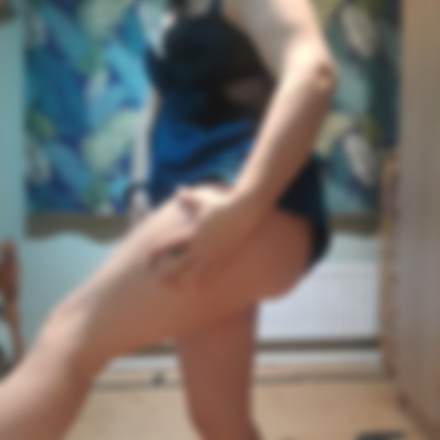 Montrant un petit tatouage sur la jambe.