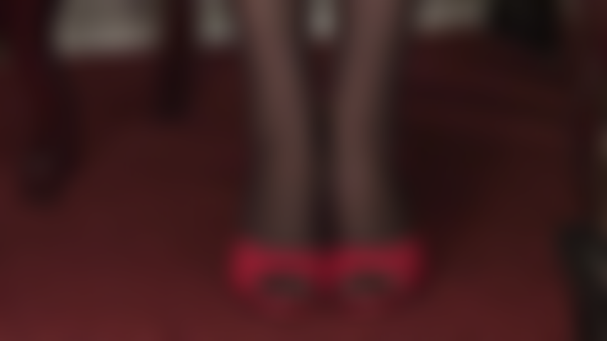 Séduction par les talons hauts et les bas - des claquettes rouges sexy à talons hauts et des collants noirs à coutures à motifs floraux sont une pure séduction.