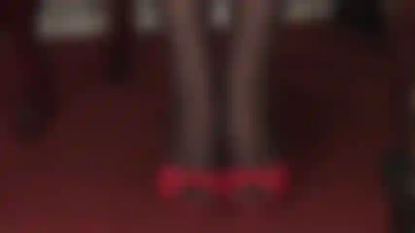 Séduction par les talons hauts et les bas - des claquettes rouges sexy à talons hauts et des collants noirs à coutures à motifs floraux sont une pure séduction.