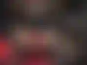 Gants en cuir rouge sur un énorme strapon noir.