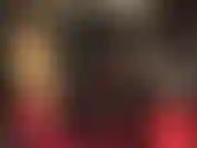 Une maîtresse blonde en combinaison moulante en pvc brillant.