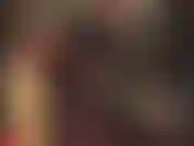 Combinaison moulante en latex noir et gants rouges.