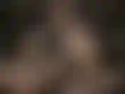 Une déesse du cuir portant des lunettes sexy, caresse son énorme strapon blanc.