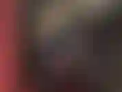 Maîtresse vêtue d'une combinaison en vinyle noir brillant, des sangles sur l'une de ses énormes bites, un strapon blanc épais, poussant et fessant.