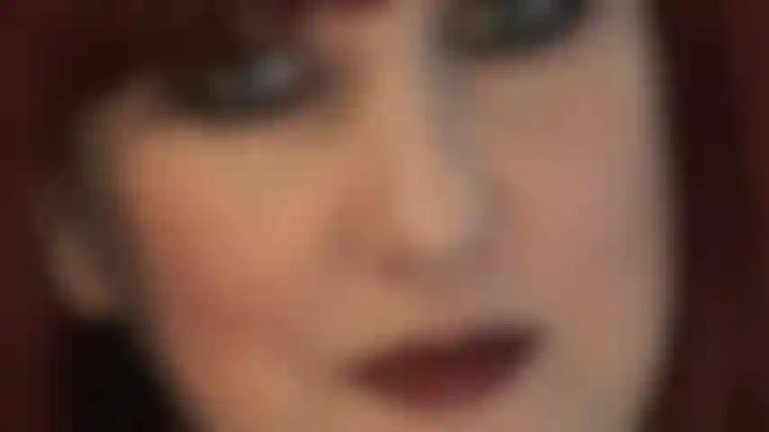 Des lèvres foncées extra brillantes et des yeux séduisants.