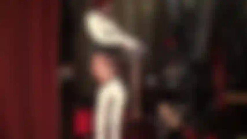 Une infirmière sexy en latex superpose plusieurs paires de collants nude brillants sur des bas et des collants en latex.