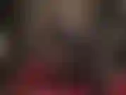 Je porte des bas en latex noirs et rouges et des gants jusqu'aux épaules ainsi que des escarpins à bout ouvert brillants.