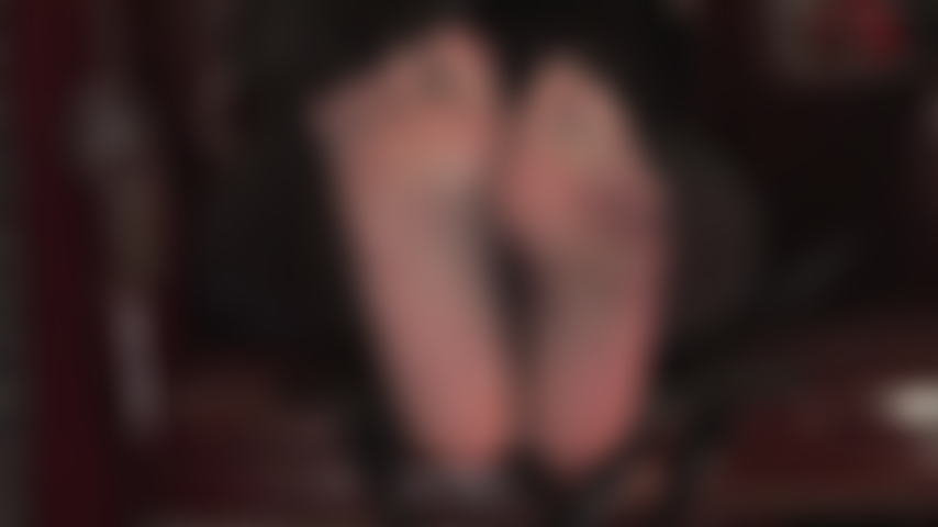 Des pieds sexy se tortillent dans des collants noirs transparents taquinant l'esclave des pieds.