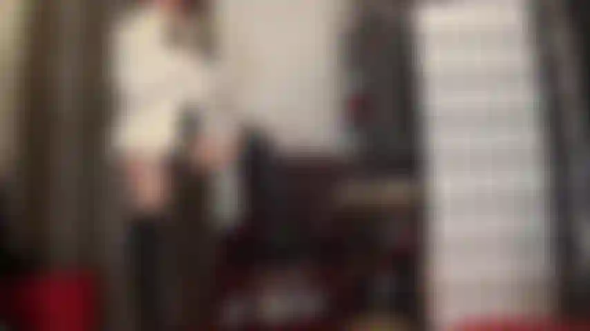 Maîtresse strapon en cuir noir, collants brillants et manteau de fourrure blanc - déesse du cuir et de la fourrure branle sa grosse bite noire en tenant un stylo comme une cigarette et en taquinant avec sa belle jupe en cuir et ses longues bottes.