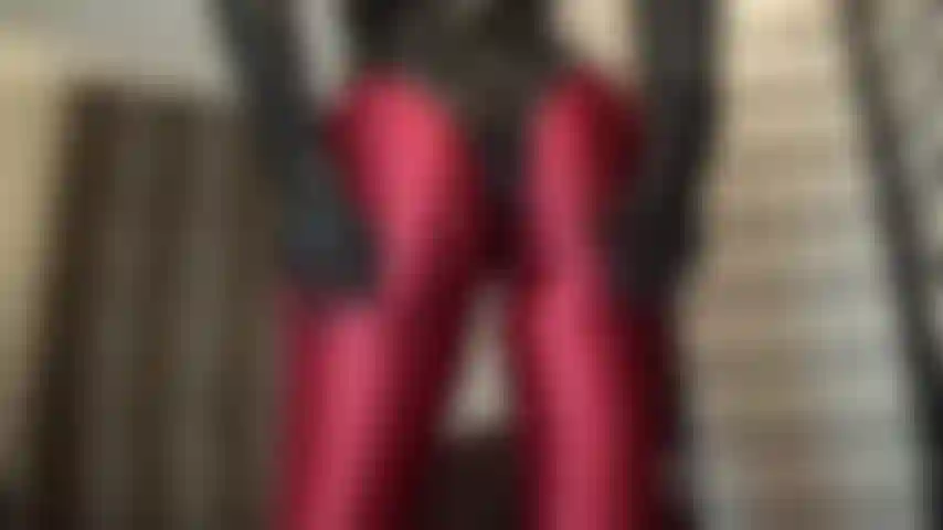 Un collant en spandex rouge brillant et un body string moulant en pvc - oh, avoir ce fabuleux cul rond abaissé sur ton visage, même juste pour un reniflement... Maîtresse touche et serre ses fesses parfaites avec des gants en cuir - si près de toi.