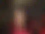 Collants nude sexy, jambes taquines, cheveux noirs, cuir noir, body rouge et talons aiguilles rouges à bride à la cheville.