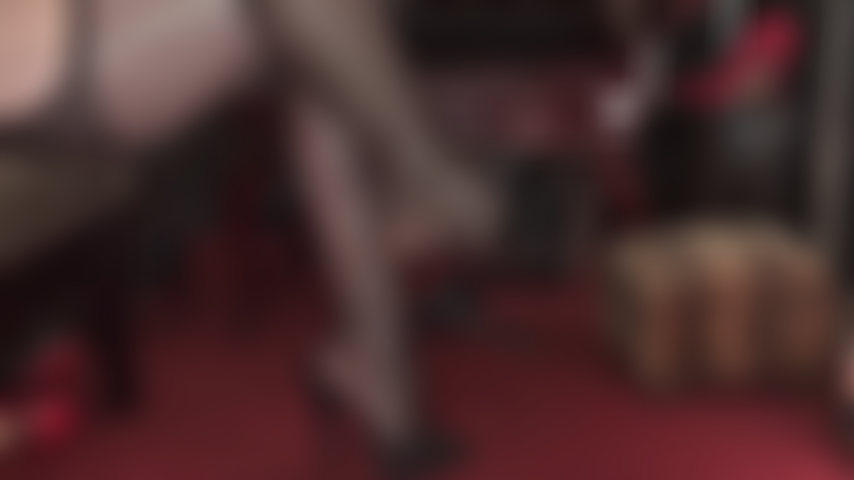 Worship Mistress' high heeled black leather mules, shapely feet and legs in garter pantyhose.