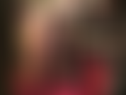 Maîtresse en soutien-gorge, collants et talons caressant sa bite noire de 20 cm, sentant de haut en bas ses jambes soyeuses en nylon transparent.