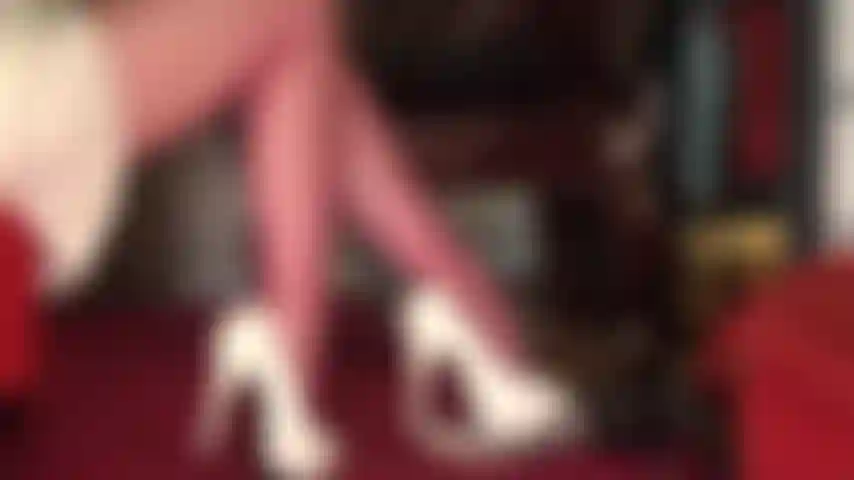 De belles cuisses et jambes en collants rouges avec des vues sous la jupe dans une jolie jupe en satin.