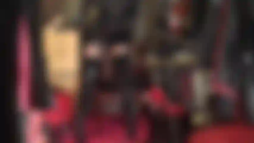 Body en pvc et nylon assis sur le visage - bottes hautes, collants brillants, jupe en pvc et body en nylon transparent en dessous.