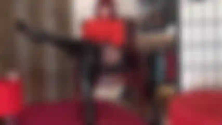 Je vénère mon corps dans cette tenue sexy composée d'un body rouge, d'une jupe en vinyle brillant, de collants noirs et de hautes bottes en cuir verni noir jusqu'aux genoux.