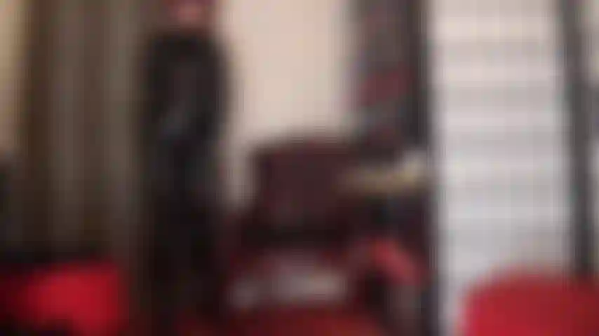 Fétichiste du pvc - admirez les courbes brillantes de la maîtresse vivian dans cette combinaison en vinyle noir avec des bottes au-dessus des genoux et des gants en cuir.