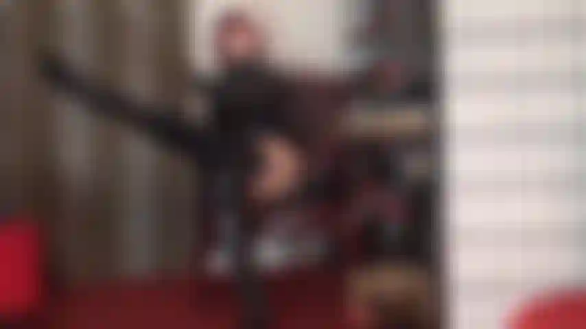 Une allumeuse de bite en bottes brillantes jusqu'aux genoux, en pvc et en bas avec jarretelles sur des collants beiges - les courbes sexy et brillantes de la maîtresse vous rendent fou.