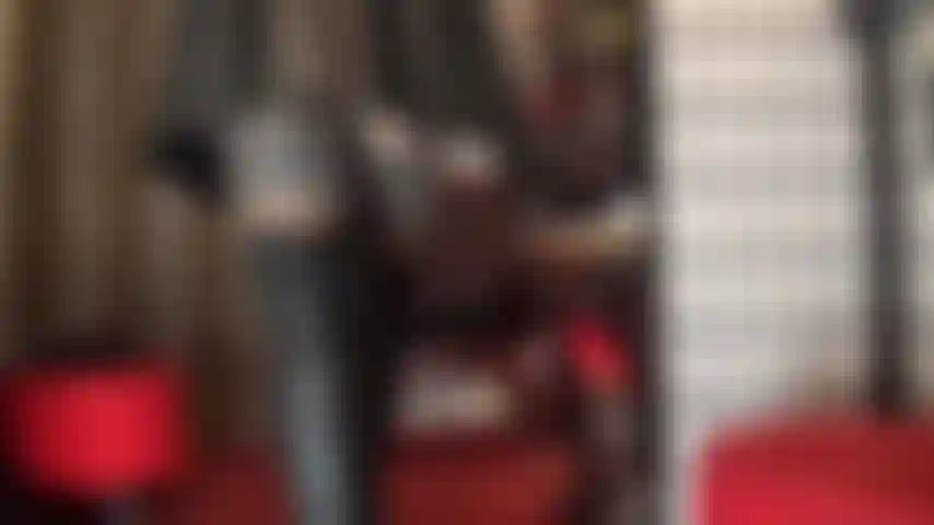 Une déesse du cuir adorée - la maîtresse est vêtue d'un beau cuir noir, d'une mini-jupe moulante et de hautes bottes au-dessus des genoux, de bas et de collants en dessous.