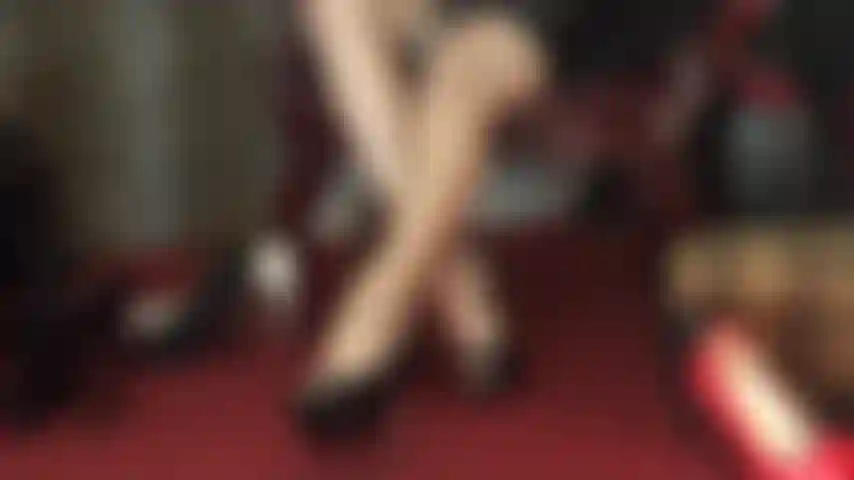 Pure séduction - de longues jambes croisées qui se ferment et s'ouvrent dans des collants brillants, offrant des vues tentantes entre les deux.