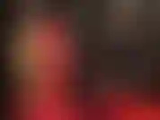 Maîtresse en latex rouge et noir. La jupe se raccourcit, puis se transforme en une mini-jupe noire étriquée, suivie de bas en dentelle de nylon blanc sur du latex. Tellement sexy !