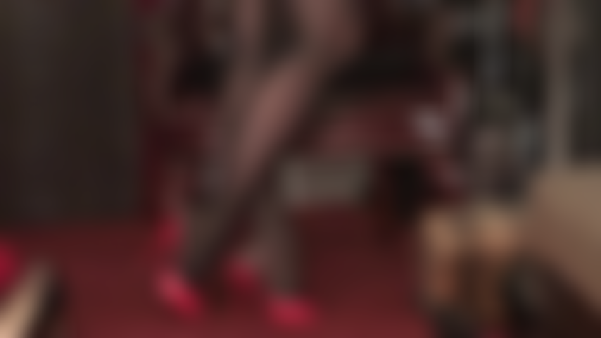 Collants extra brillants noirs brillants et mules rouges à talons hauts.