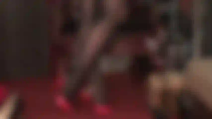 Collants extra brillants noirs brillants et mules rouges à talons hauts.