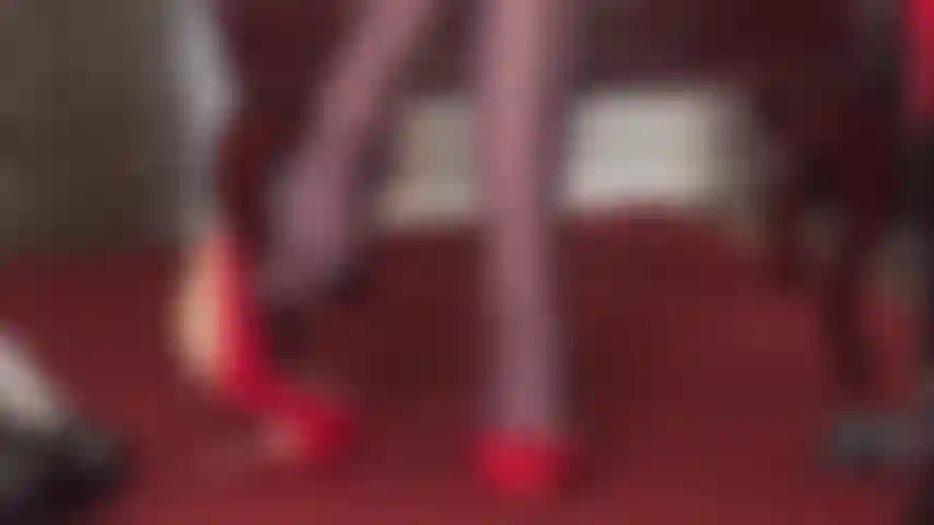 Maîtresse vivian montre ses talents de danseuse avec une paire d'escarpins rouges brillants et des collants marron foncé brillants, cravache à la main.