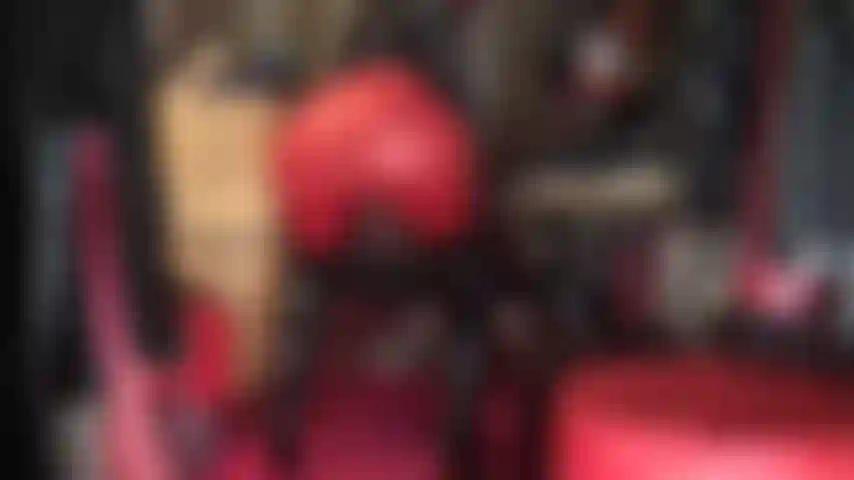 Assise sur le visage et adorant le cul en leggings rouges, bottes vernies brillantes au-dessus des genoux et capuche en spandex.