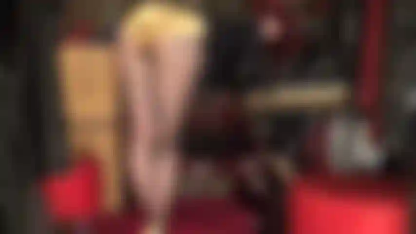 Maîtresse vivian est penchée sur sa table, regardant en arrière, taquinant avec son cul parfait dans un short en satin doré brillant.