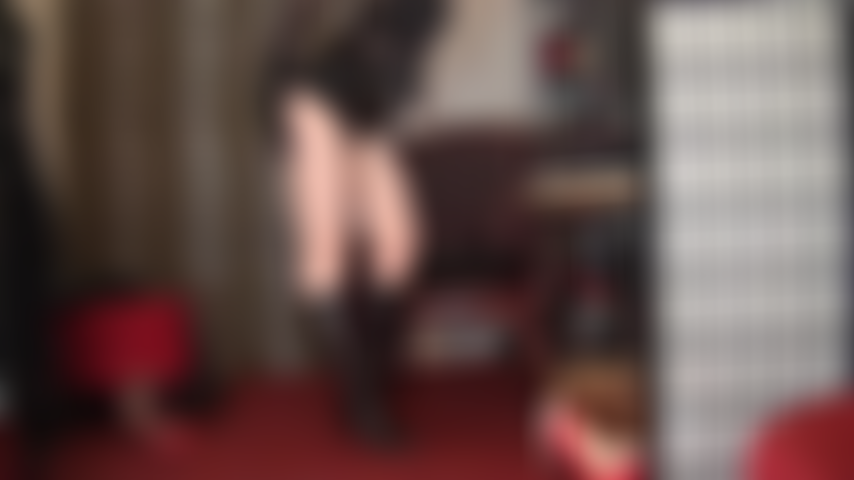 Domination de strapon géant - jambes nues, bottes en cuir aux genoux et énorme bite noire.
