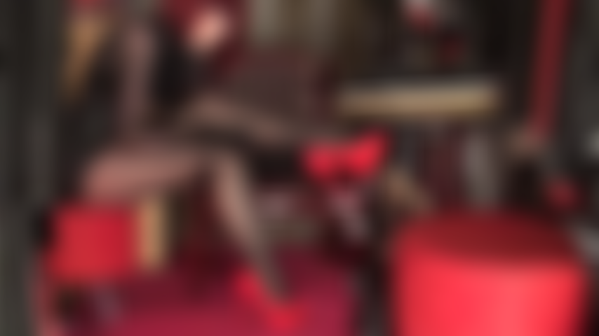 J'exhibe mes jambes en collants noirs brillants, cuir et escarpins à talons aiguilles rouges. Jambes croisées, rouge à lèvres noir, talons rouges flamboyants.