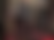 Une dominatrice en latex vêtue d'un legging noir moulant, de gants en latex rouge vif et d'un gros gode ceinture blanc. J'adore mon cul et ma bite.