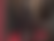 Une déesse fétichiste du latex pervers en combinaison en caoutchouc noir avec capuche et strapon bbc.