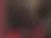 Une déesse fétichiste du latex pervers en combinaison en caoutchouc noir avec capuche et strapon bbc.