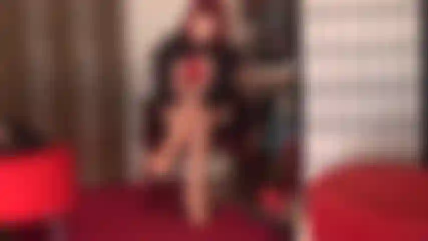 Tentante en rouge - maîtresse vivian enfile une paire de bas en dentelle rouge sur des collants nude brillants, des escarpins à talons aiguilles rouges et des gants en cuir rouges.