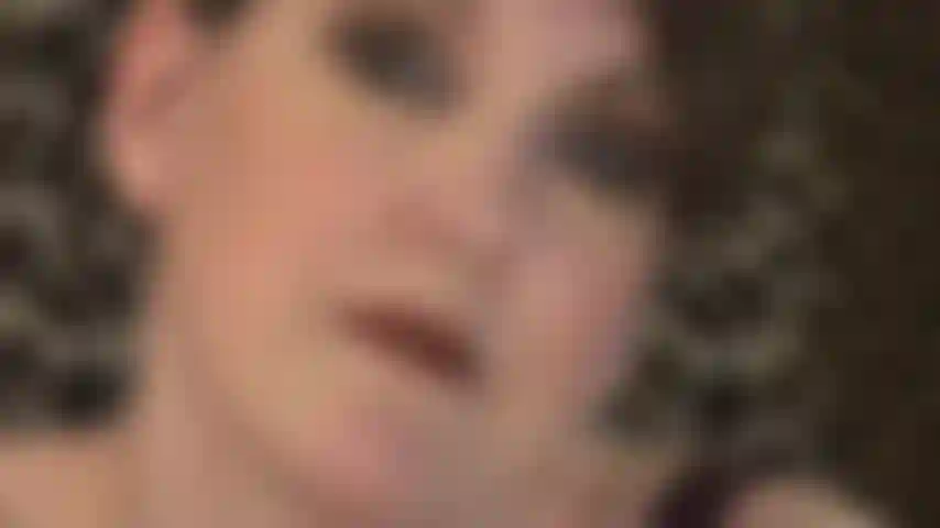 Une maîtresse de culte au beau visage et aux cheveux courts.