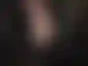 Déesse du cuir taquine avec la fermeture éclair de son haut abaissée, offrant une vue sur un joli soutien-gorge en dentelle et un décolleté.