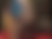 Une allumeuse séduisante avec des jambes et un cul en nylon dans des collants noirs brillants et soyeux et du latex bleu.