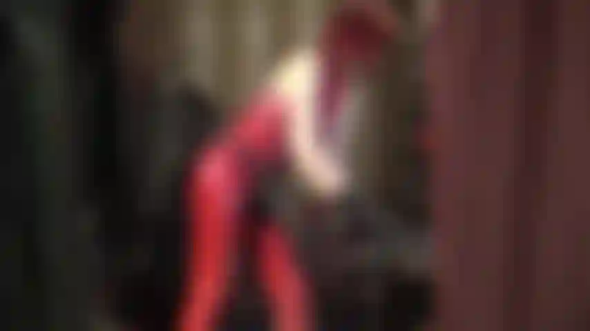 Un énorme strapon noir et une combinaison en caoutchouc rouge.