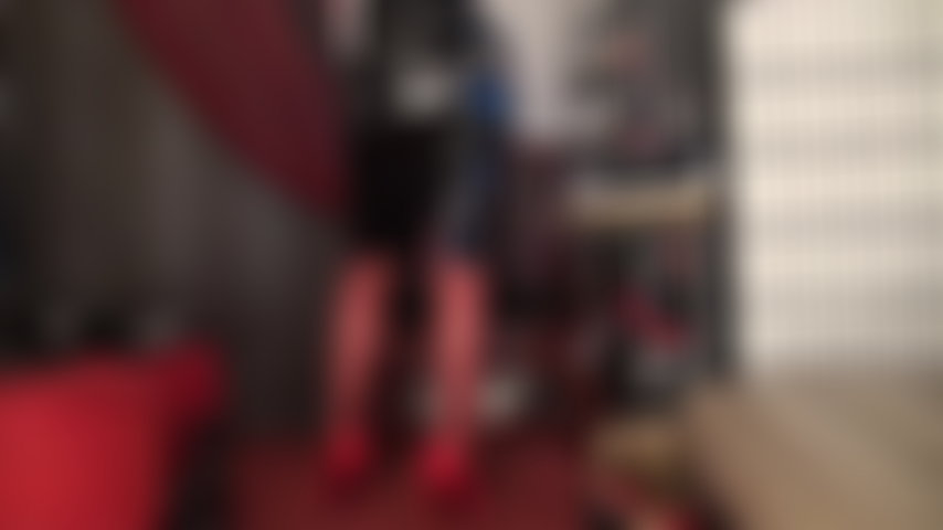 Bas rouges, talons et jupe en vinyle noir brillant.
