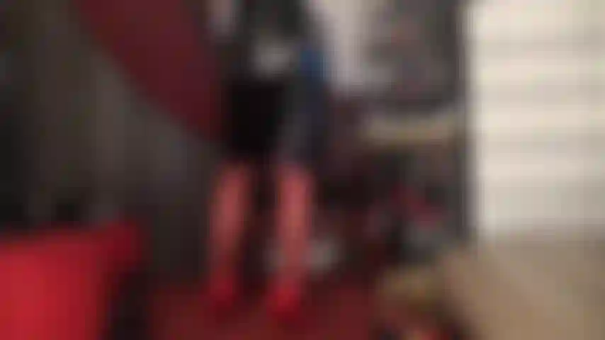 Bas rouges, talons et jupe en vinyle noir brillant.