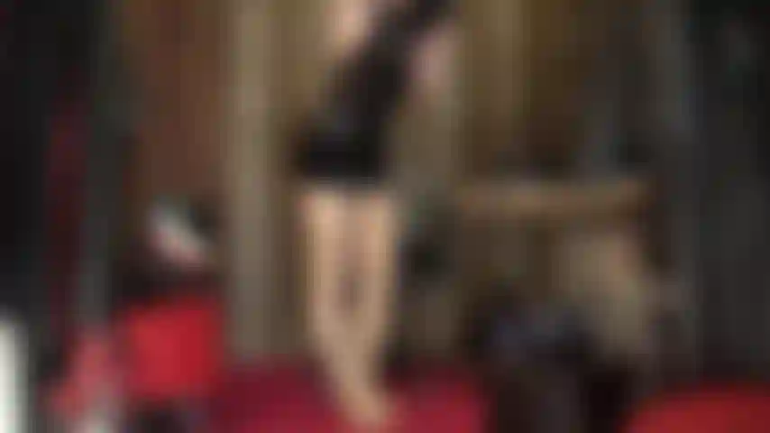 Fétichiste intense du latex avec de longs gants, une capuche en caoutchouc et des couches de collants brillants, des taquineries sous la jupe et un culte du masque en latex.